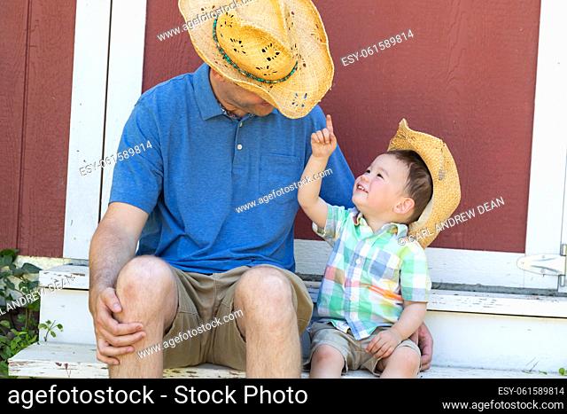 Playful Young Caucasian Father and Mixed Race Chinese Son Wearing Cowboy Hats