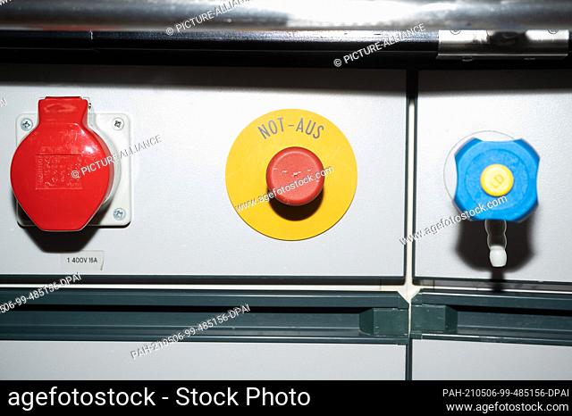 PRODUCTION - 28 April 2021, Hessen, Fulda: A switch marked ""emergency stop"" under a desk in a lecture hall at Fulda University of Applied Sciences