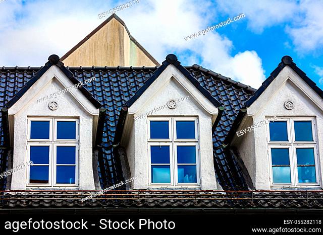 mansard windows in old style on roof in medieval house