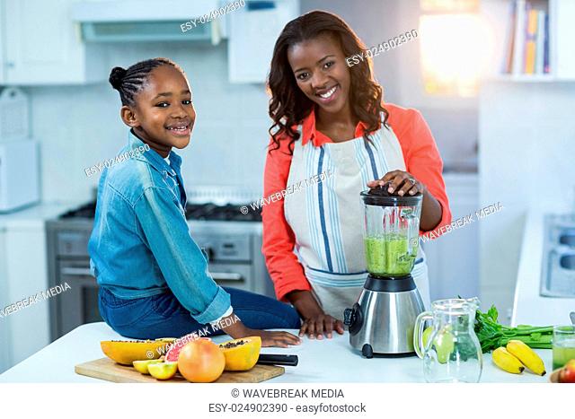 Woman and daughter using mixer