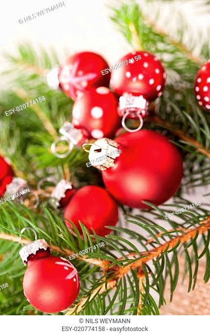 Schöne rote Weihnachtskugeln mit kleinen Weißen Punkten mit grünen Tannenzweigen