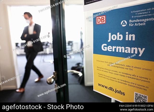 14 April 2022, North Rhine-Westphalia, Cologne: A man walks past a poster reading ""Job in Germany"" at a job counseling center at the main train station