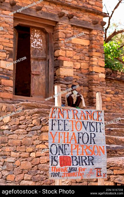 Yeha, Tigray Region, Ethiopia - April 28, 2019: Orthodox priest back of entrance to Great Temple of the Moon from 14th century in Yeha, Ethiopia