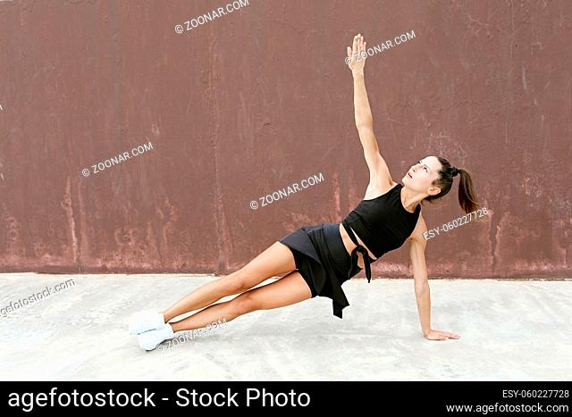 Motivated attractive healthy caucasian sportswoman doing sport outdoor, training quay facing sunrise. High quality photo