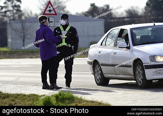 Czech police officers with respirators check vehicles passing through a checkpoint near Litovel, Czech Republic, on March 16, 2020