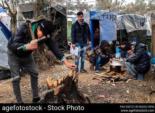 21 January 2020, Greece, Lesbos: Migrants prepare their food in a temporary camp next to the camp in Moria. The camps on the islands of Lesbos, Samos, Chios