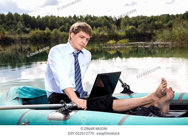 Dressed man in boat and reading