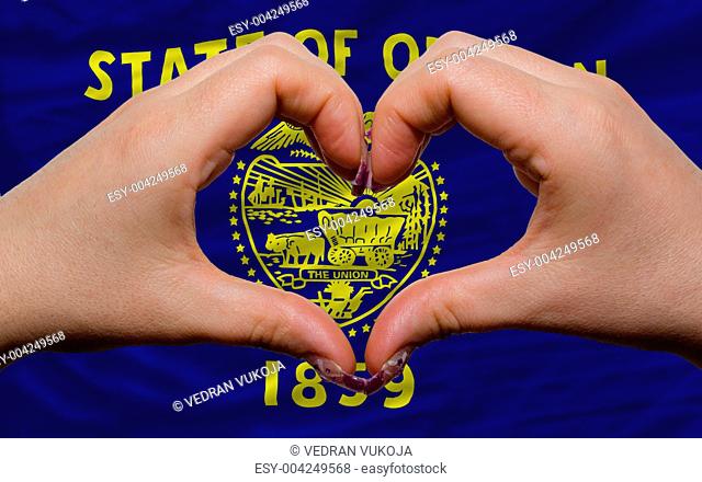 over american state flag of oregon showed heart and love gesture