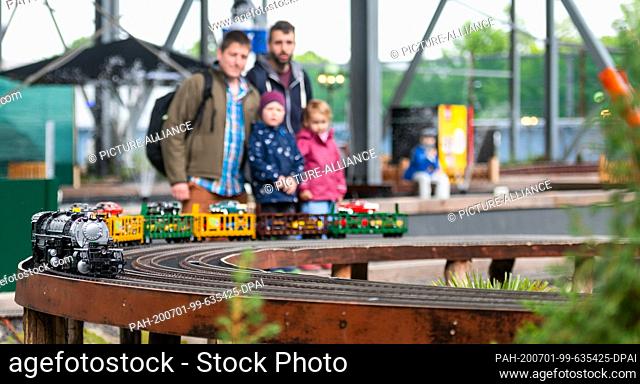 01 July 2020, Lower Saxony, Bispingen: Visitors look at a passing train on the model railway layout. A total of 500 trains are to roll through various theme...