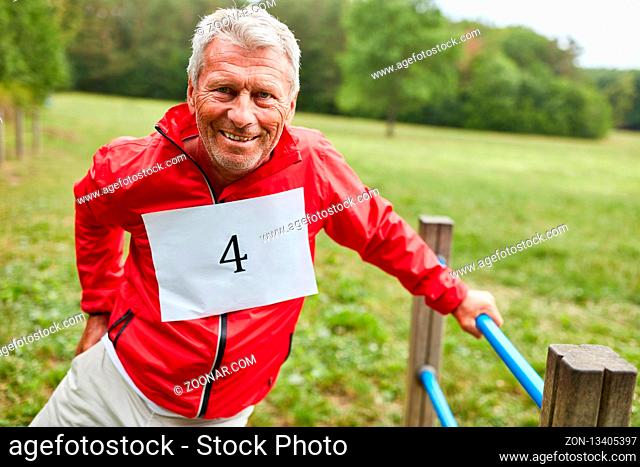 Senior Mann auf dem Trimm dich Parcours in der Natur macht eine Fitness Übung