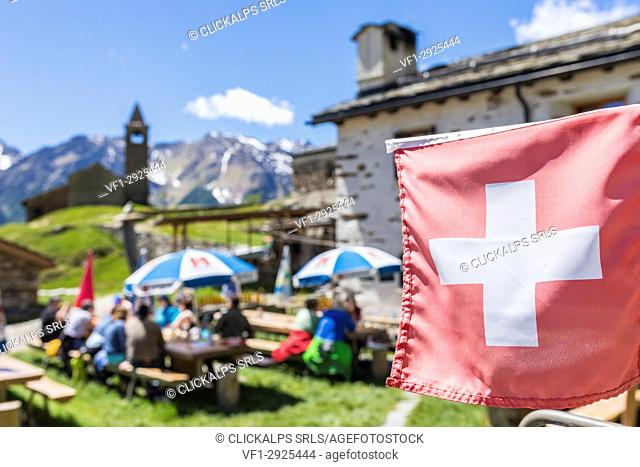 Swiss flag at the mountain retreat, San Romerio Alp, Brusio, Canton of Graubünden, Poschiavo valley, Switzerland