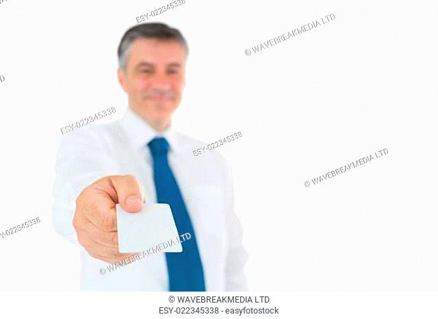 Smiling businessman holding out his business card