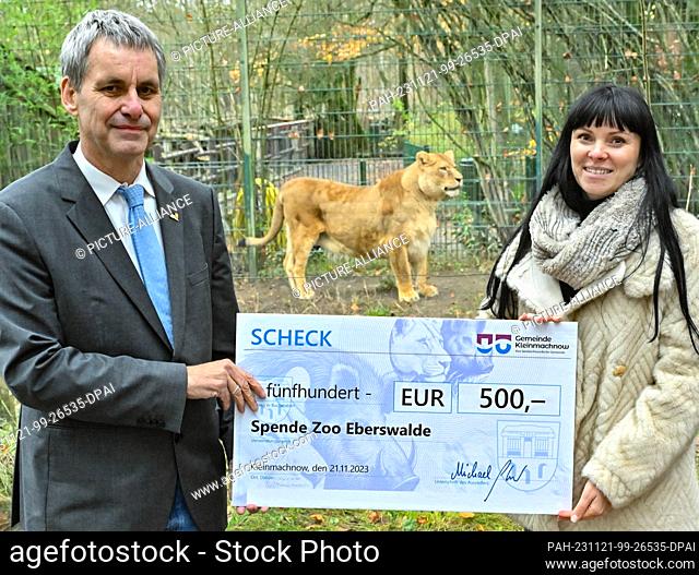 21 November 2023, Brandenburg, Eberswalde: Michael Grubert (SPD), Mayor of Kleinmachnow, hands over a donation cheque for 500 euros to Paulina Ostrowska