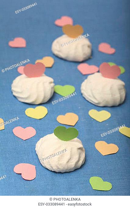 Marshmallow on a blue tablecloth decorated with coloured paper hearts