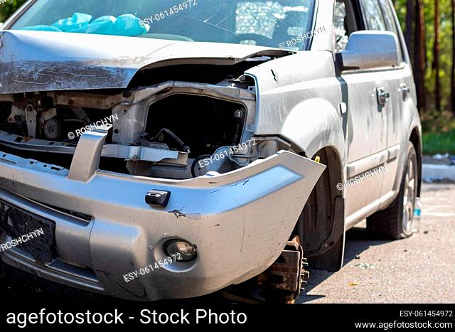 Broken headlights as a result of a collision. Broken gray car after an accident. Car accident concept. Damaged emergency headlight, hood and bumper