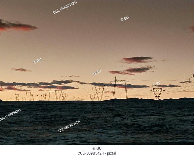 Electrical pylons in landscape at dusk, Reykjavik, Iceland