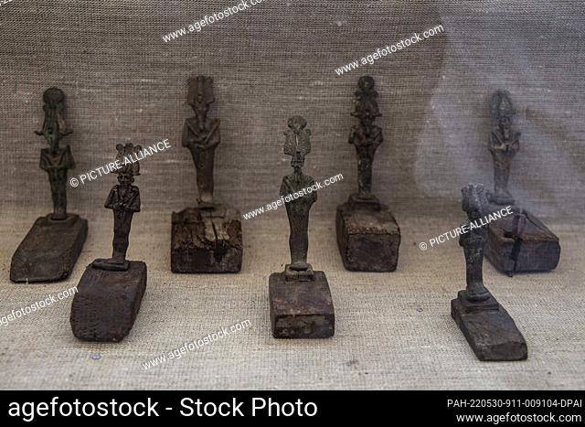 30 May 2022, Egypt, Saqqara: Bronze statues of ancient Egyptian deities lie inside a glass box at a media opportunity during which a new archaeological...