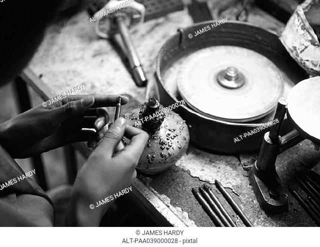 Person standing in front of workbench, focus on hands, b&w