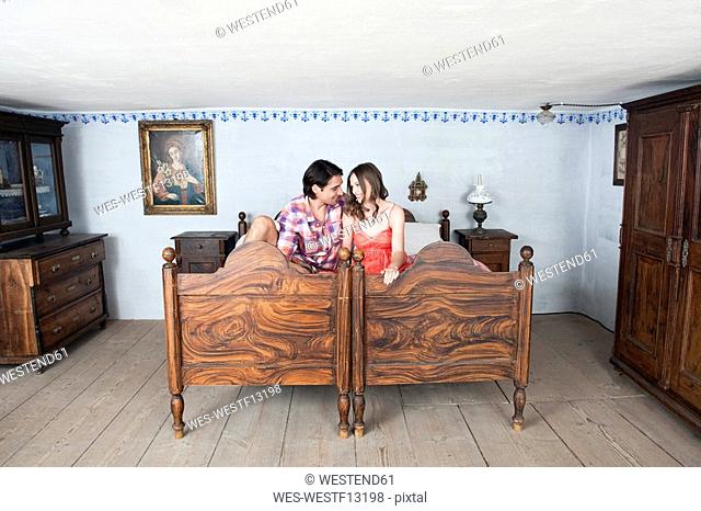 Germany, Bavaria, Young couple in rural bedroom