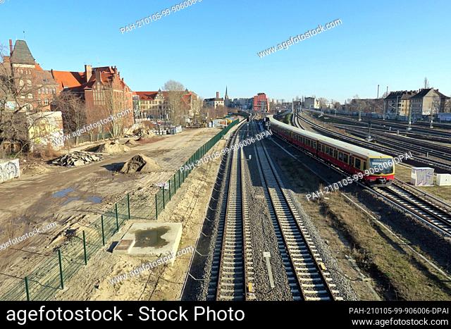 08 February 2020, Berlin: An S-Bahn of the line S7 Potsdam runs near the station Ostkreuz. On the left is the leveled area for the future course of the tram
