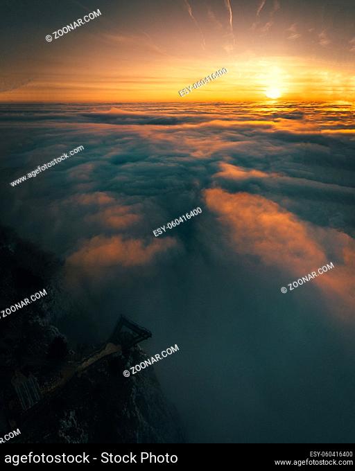 mountain peak with fog during sunrise in austria hohe wand
