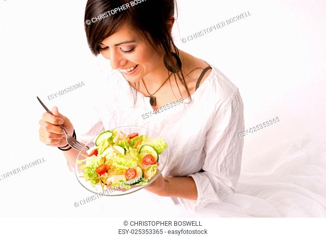 An attractive woman takes in the aroma of the salad she is about to consume