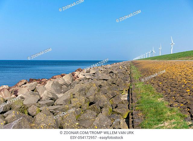 Dutch dike along the sea with wind turbines