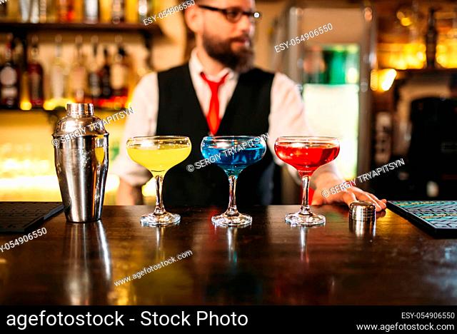 Bartender behind bar counter show alcohol coctails in restaurant