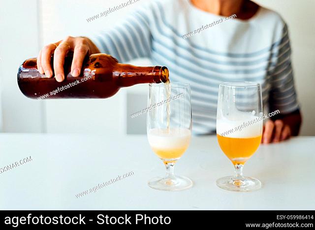 Woman pouring a refreshing beer in a glass