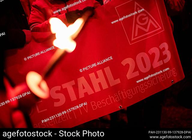 30 November 2023, North Rhine-Westphalia, Duisburg: A demonstrator holds a banner with the words ""Steel 2023"" during a protest in the course of the current...