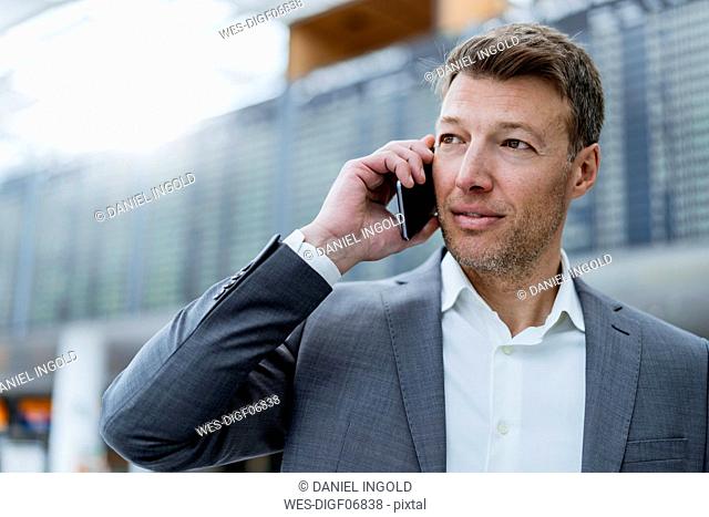 Portrait of businessman on cell phone at the airport