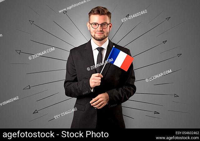 Smiling young man standing with flag and multidirectional arrows around