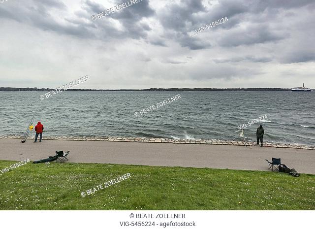 Zwei Angler in wetterfester Kleidung trotzen dem Regenwetter an der Promenade von Kiel-Holtenau - Kiel-Holtenau, Schleswig-Holstein, Germany, 29/04/2016