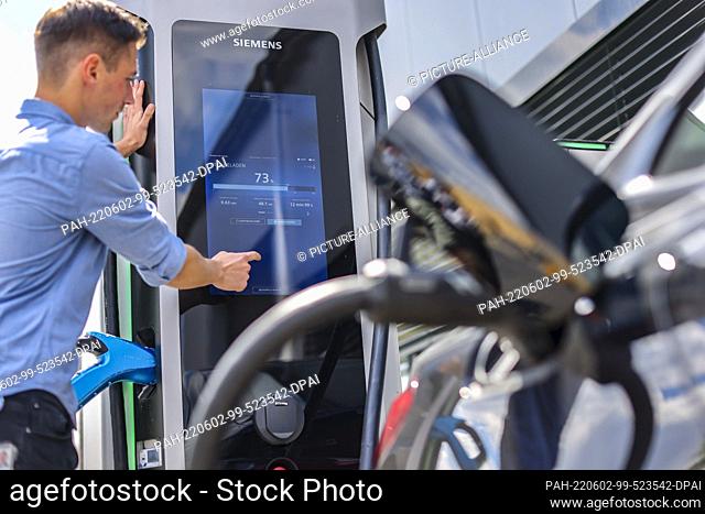 02 June 2022, Saxony, Leipzig: Christian Rühl, hardware system architect at Siemens, charges a BMW i4 electric car at a SICHARGE D charging station at the...