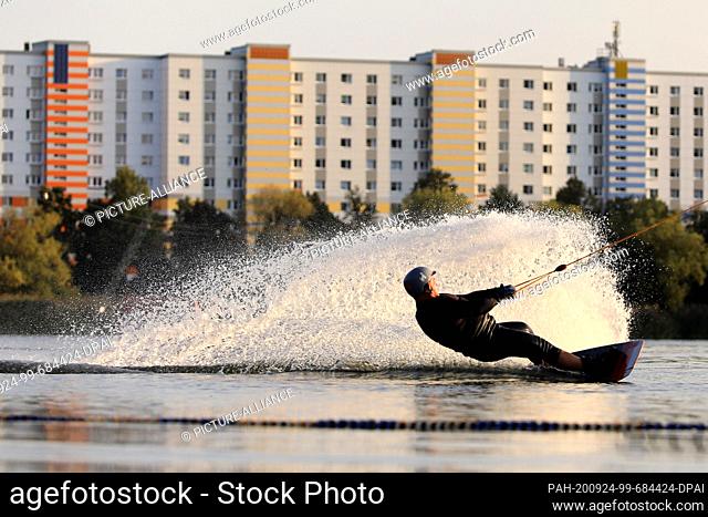 17 September 2020, Saxony-Anhalt, Magdeburg: Leisure sportsman Peter Heilemann glides over Lake Neustadt in Magdeburg with a so-called wakeboard at the water...