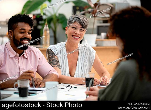 Female graphic designer looking at the camera while sitting at table