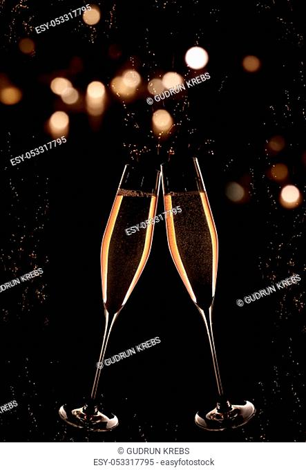 Vertical dark background with golden champagne and luminous bokeh at the turn of the year