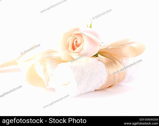 Rose with decorative ribbons over Rolled up Bath Towels