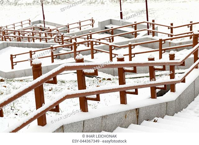 concrete steps and metal rails covered with snow in the winter season , phtography is made close-up