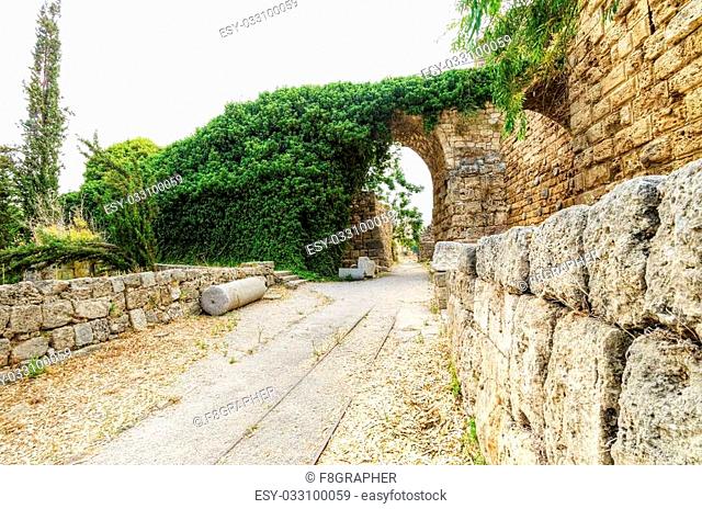 The crusaders' castle in the historic city of Byblos in Lebanon. A view of the exterior and a path, with train tracks, leading to the eastern part of the...