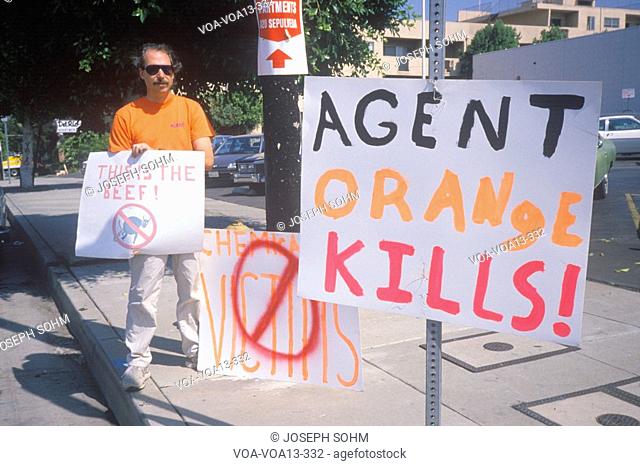 Protester against agent orange chemicals holding signs