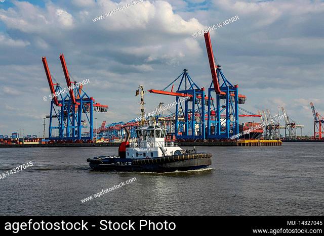 Tugboats in front of the harbor cranes in Hamburg on the Elbe River