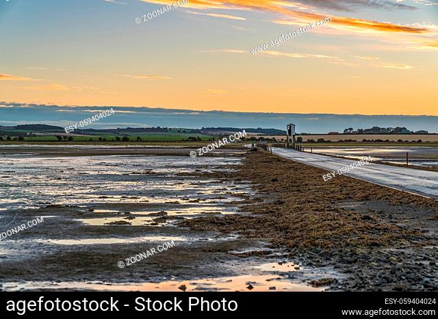 Evening sky and low tide on the road between Beal and Holy Island, Northumberland, England, UK