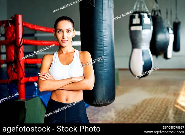 Fit confident woman posing at a boxing studio. Sport, box, workout and success concept