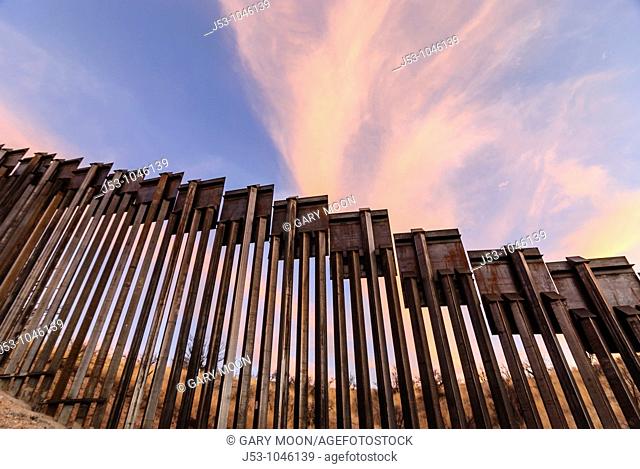 Sunset at United States border fence, US/Mexico border, east of Nogales, Arizona, USA