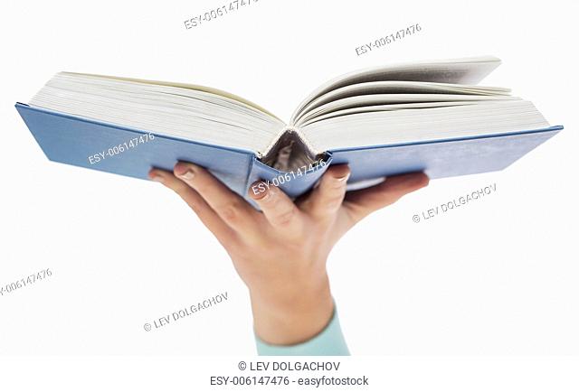 education and book concept - close up of woman hand holding open blue book
