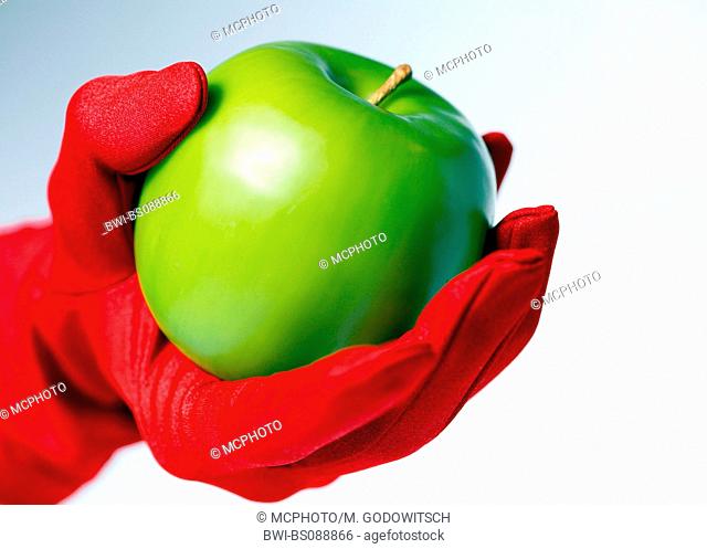 green appel held in hand with red glove