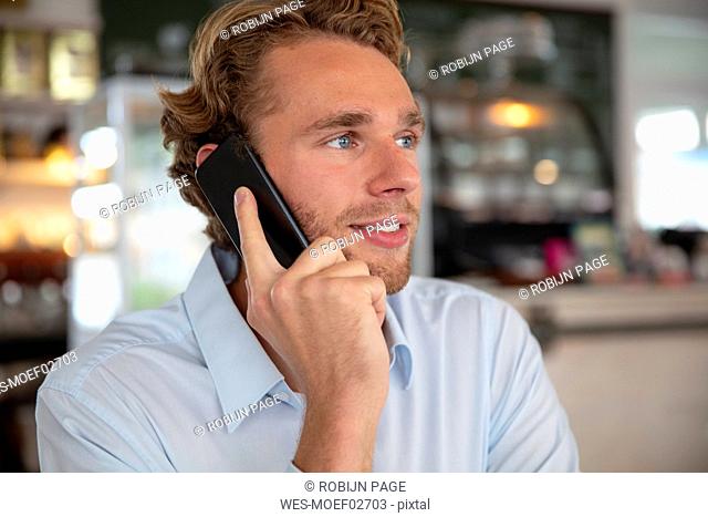 Young businessman phoning in a cafe