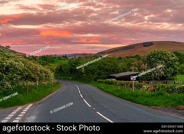 Evening clouds and a rural road in the Yorkshire Dales near Sedbergh, Cumbria, England, UK
