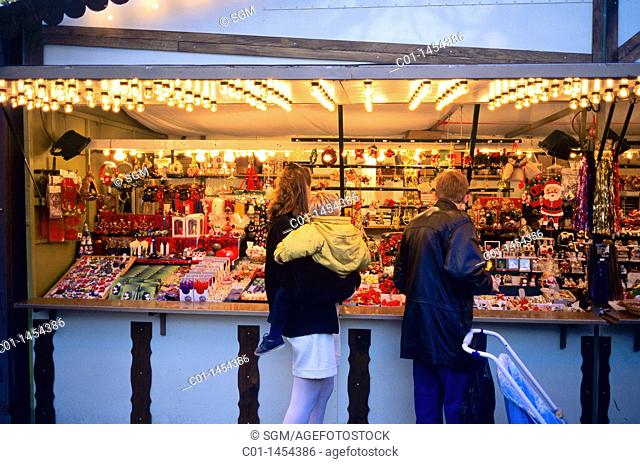 Couple with child shopping at Chritkindelsmärik Christmas market, Strasbourg, Alsace, France